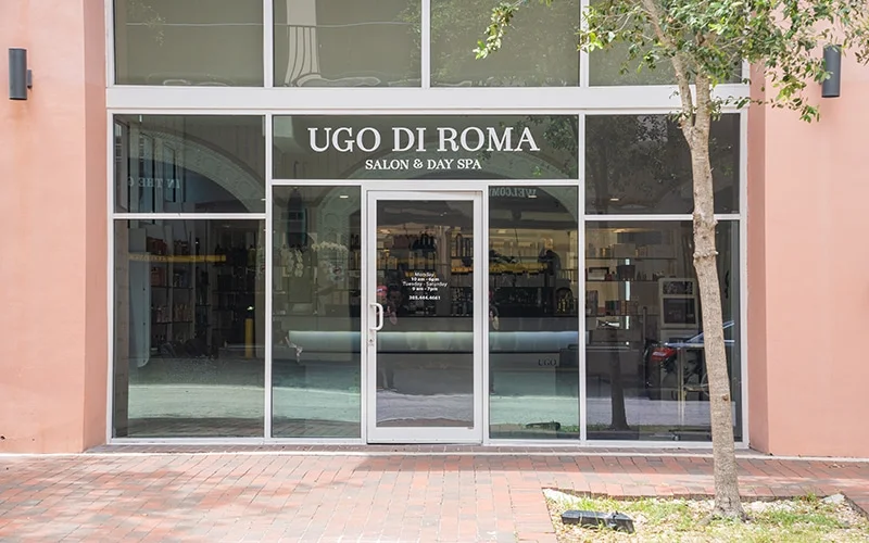 The exterior building window front of UGO salon day spa in Coconut Grove, FL.