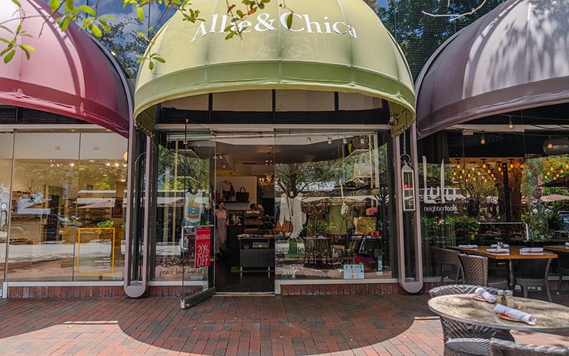 Exterior of Allie and Chica boutique's building and sidewalk in Coconut Grove, FL