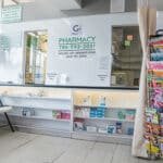 Pharmacy Sign and a magazine rack inside of Grand 7th Kwik Stop in Coconut Grove, FL.