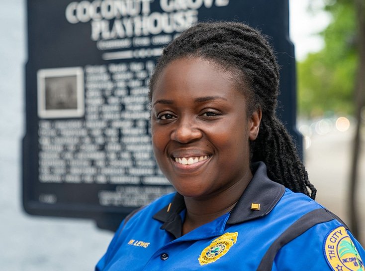 A young black policewoman smiling while in uniform.
