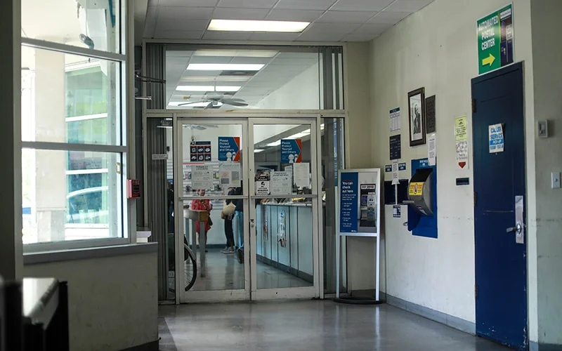 Inside of the US Post Office at Coconut Grove, FL. The front entrance doors next to the windows.