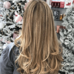 The back of a woman’s hair that has been highlighted and curled.