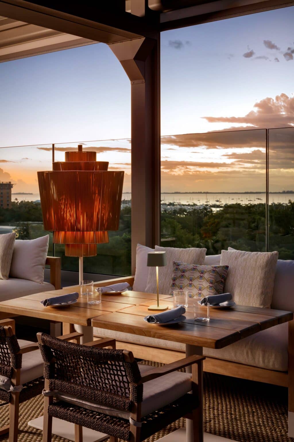 Sunset view of the marina from the outside dining area for Level 6 including chairs and bench.
