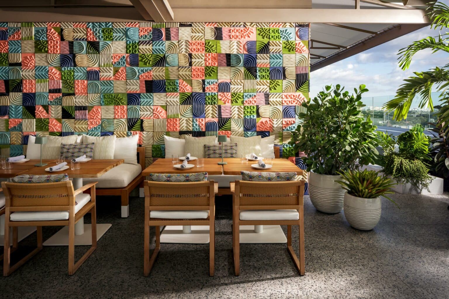 Outdoor view sitting area for Level 6 with abstract artwork don't the wall and potted plants.