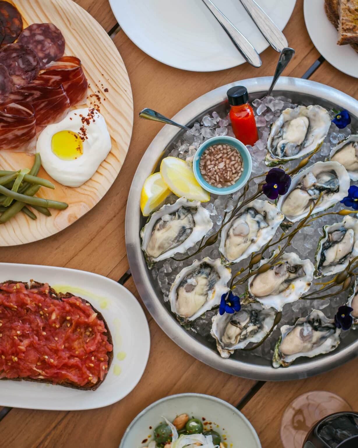 Level 6 restaurant's oyster dish with several other food options next to the bowl.