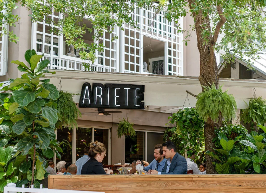 Exterior building or Ariete with people sitting outside eating their food.