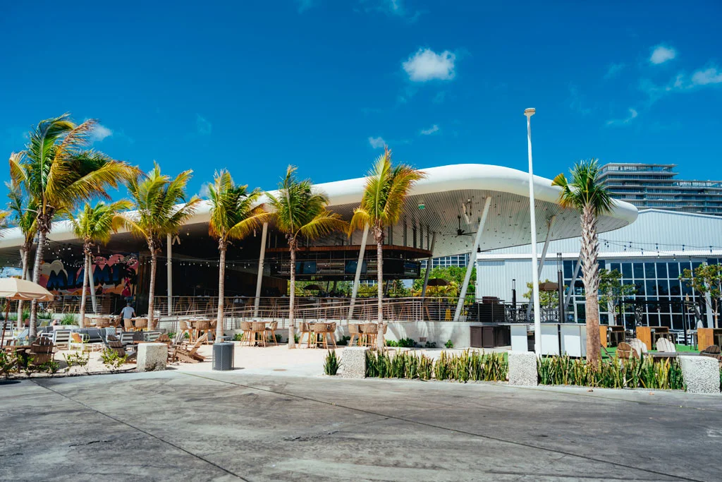 The exterior of the Bayshore Club with palm trees along the side.