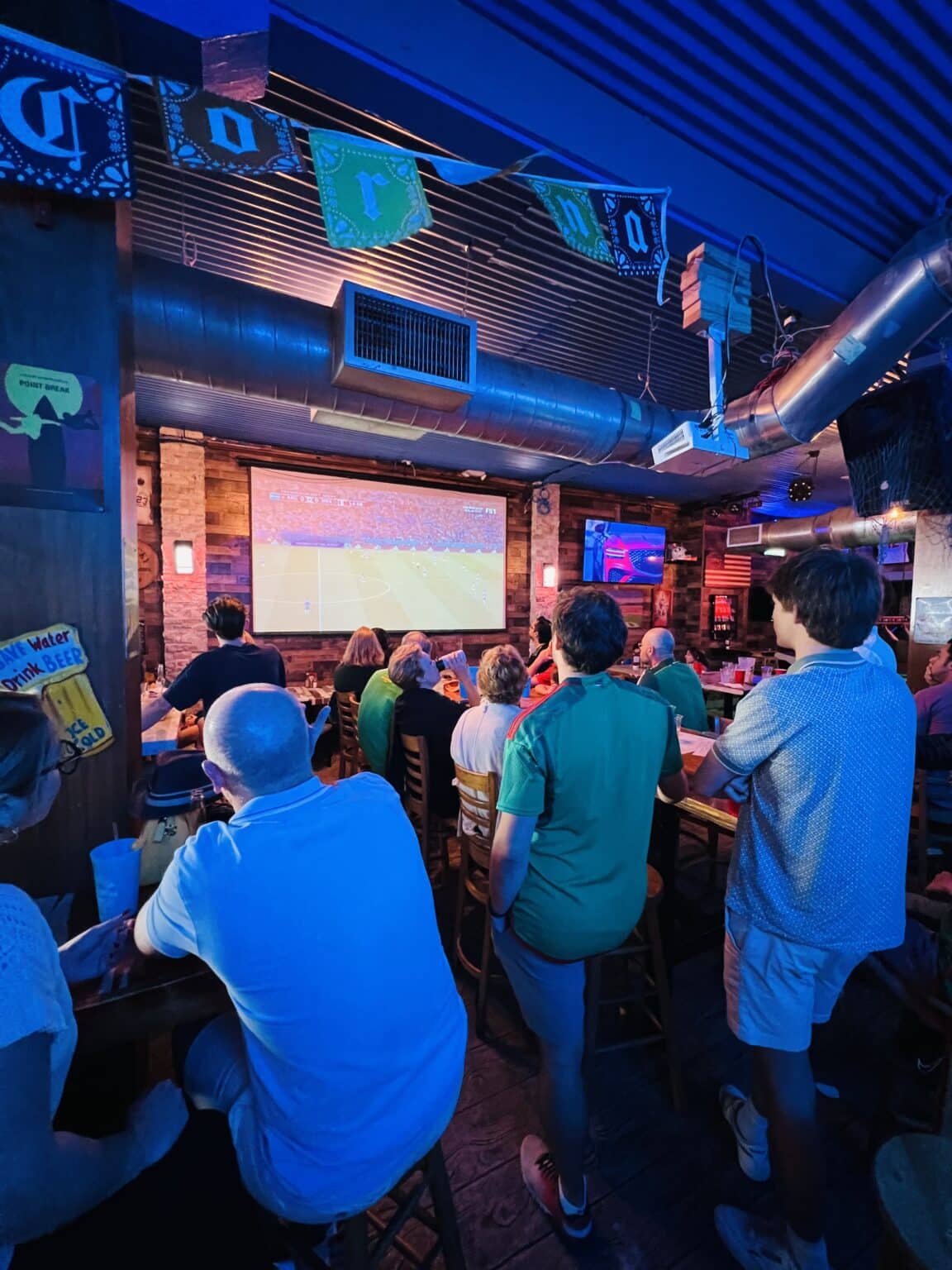 People sitting at tables at a bar area.