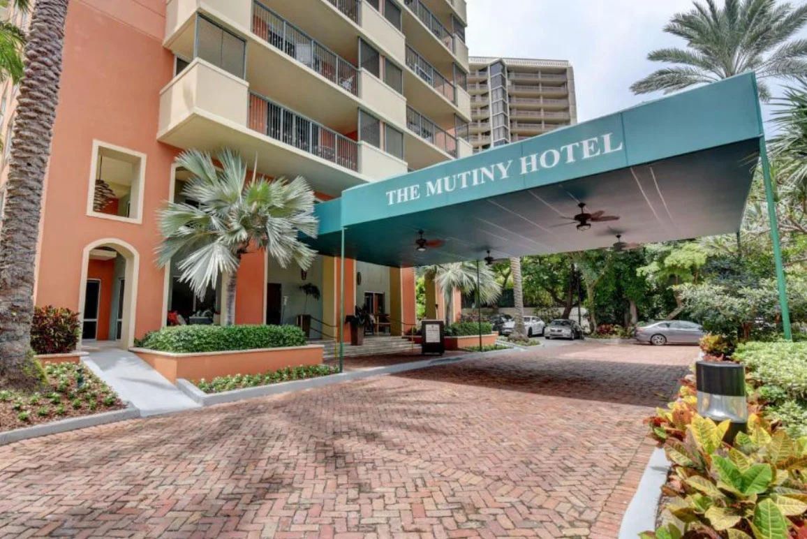 The entrance to the Mutiny Hotel, with palm trees.