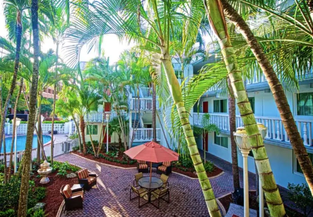 Palm trees surrounding seating area and a pool at the Residence Inn by Marriot in Coconut Grove, FL.