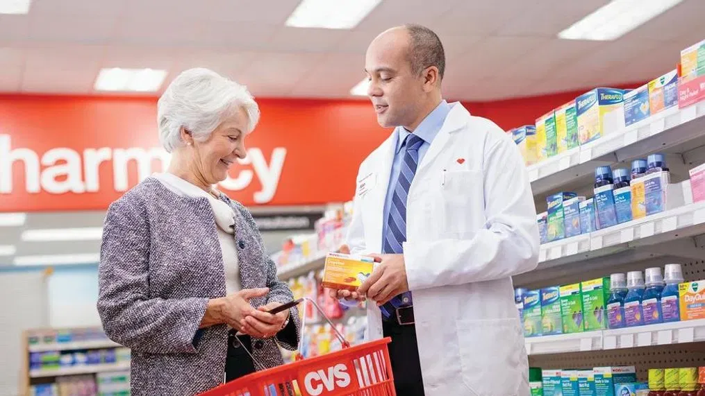 cvs staff helping older female shopper