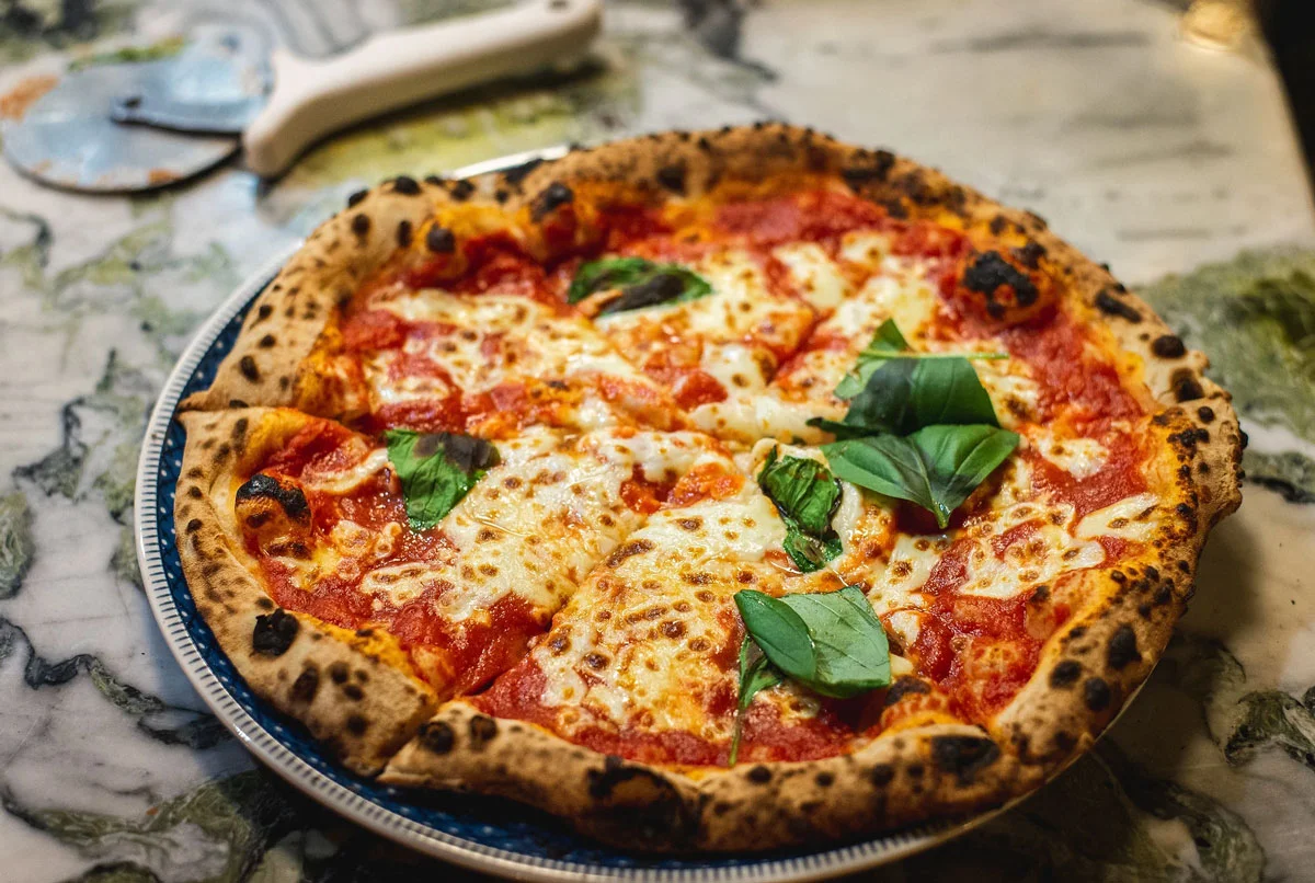 New York Roma Pizza with fresh basil, tomato sauce, and cheese