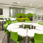 a seating area with green chairs and couches