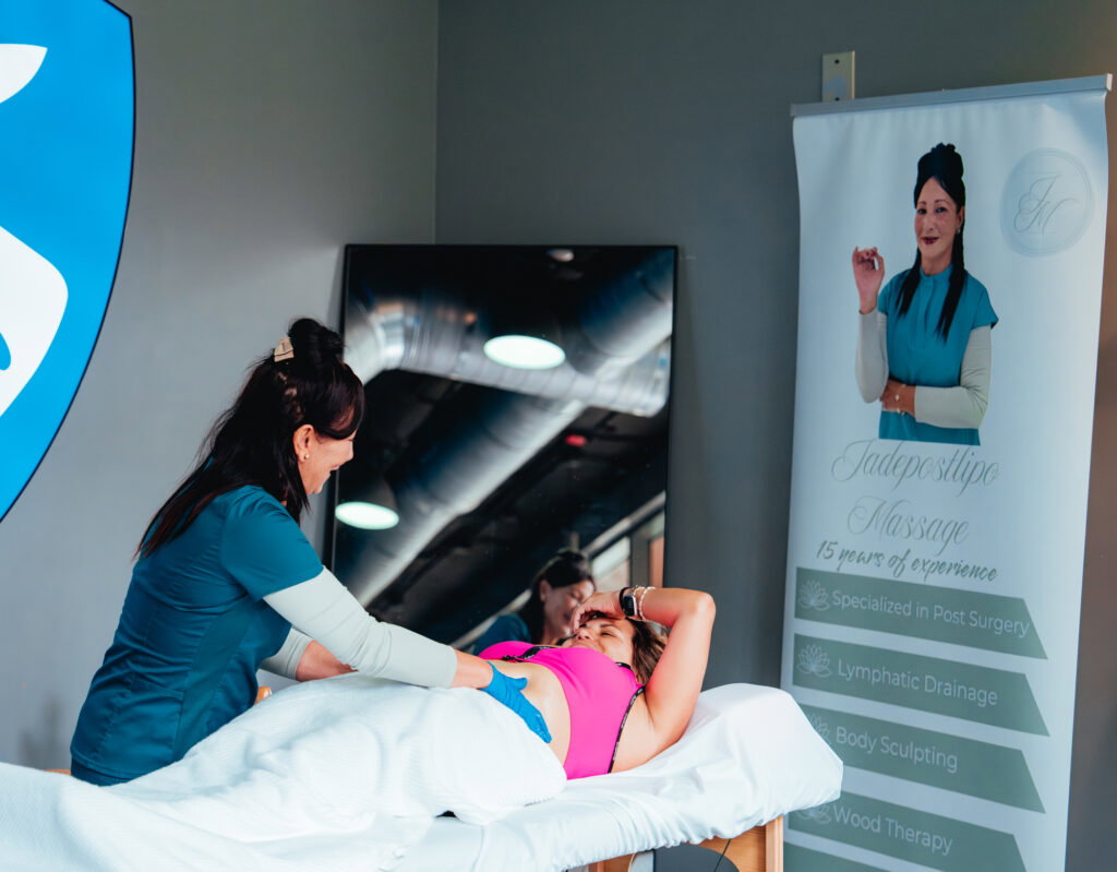 Lady performing a massage on a patient laying on a massage table.