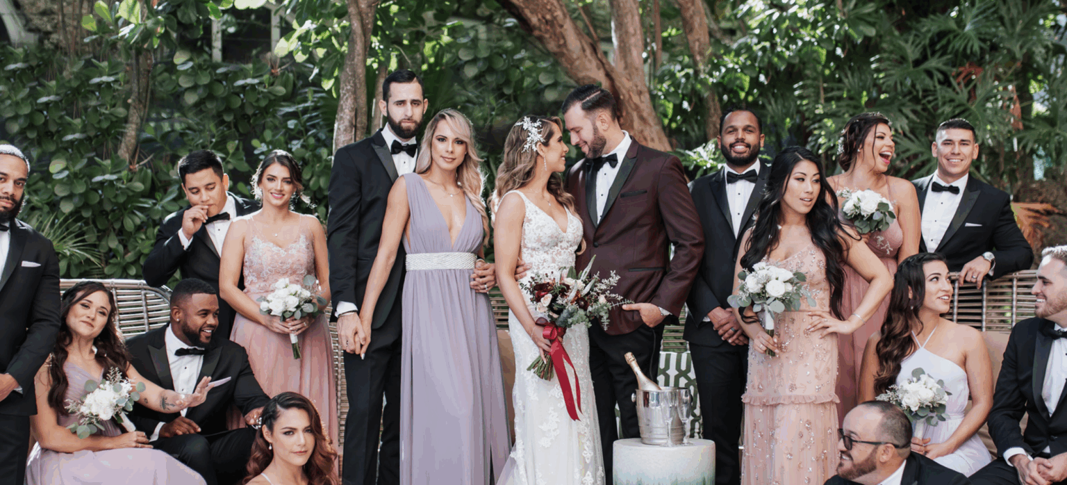 Group of people outside at a wedding ceremony posing for a photo smiling.