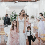 A bride holding hands of children posing for a photo.