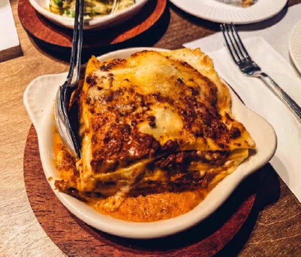 Lasagna and a spoon in a bowl.