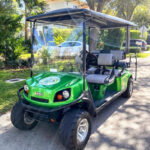 Bright green golf cart with four seats parked outside