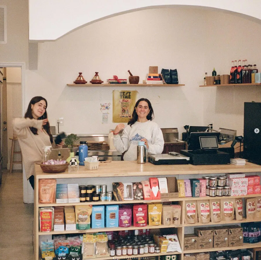 Interior of the Grove grocery store counter with two women standing behind it.