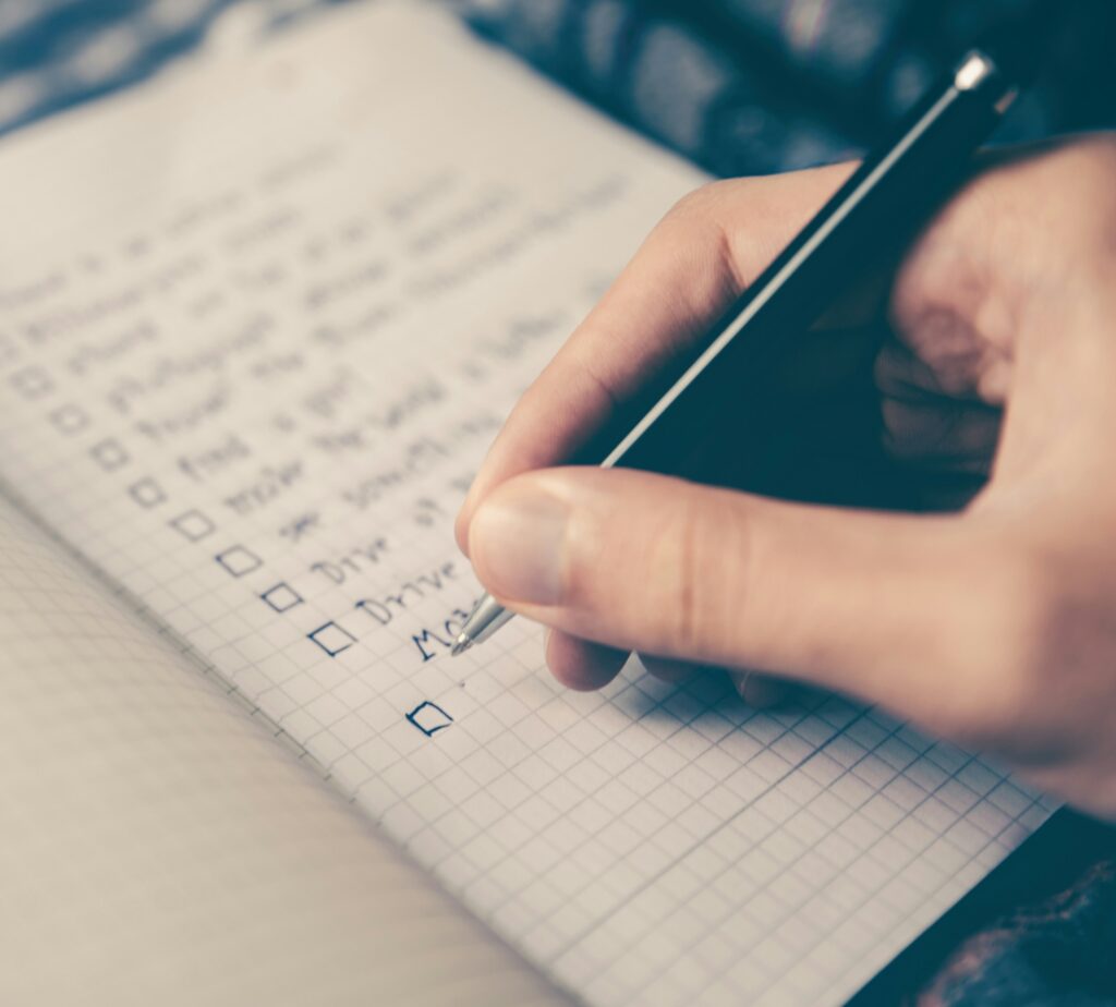 Hand writing a checklist in notebook.