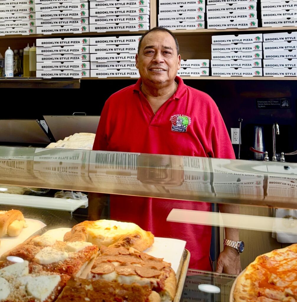 Man Sanding next to Italian food in a restaurant