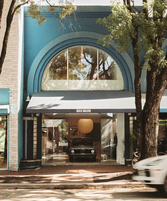 The front entrance and outer building display of Buck Mason clothing.
